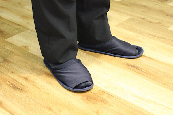 スリッパを履いている男性の足元の写真