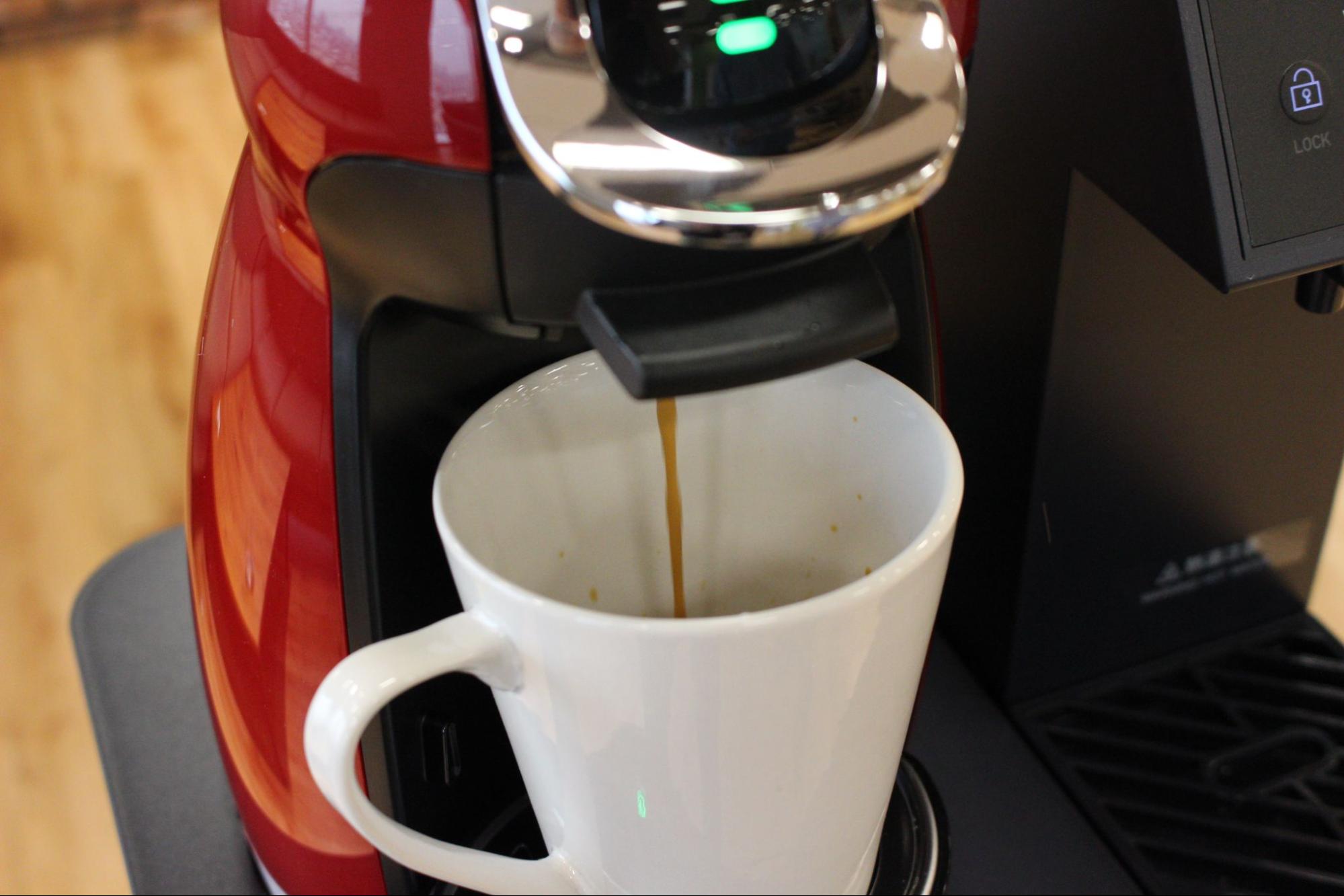 ウォーターサーバーのコーヒーをマグカップに注いでいる