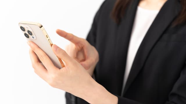 スマホ画面をチェックする写真