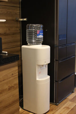 信濃湧水サーバーが冷蔵庫の隣に置かれている写真